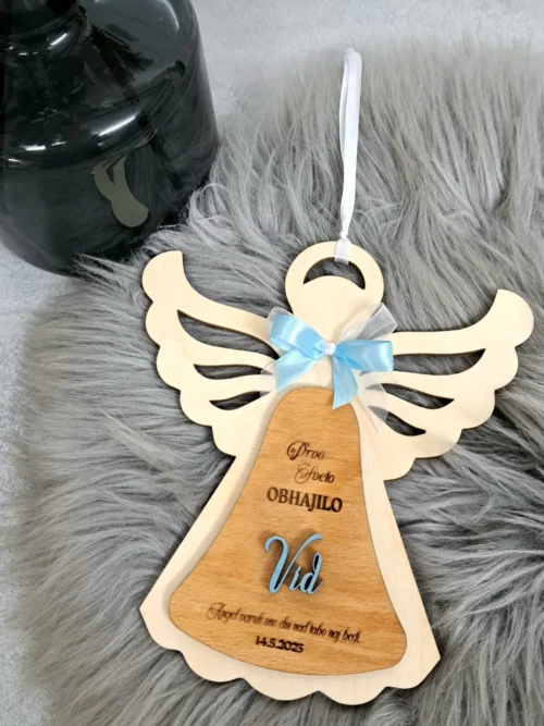 Personaliziran lesen angelček s pentljo, imenom in datumom zakramenta.