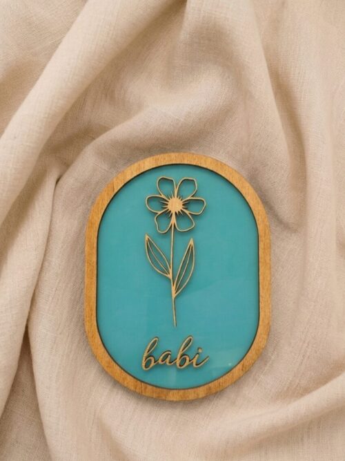 Lesena cvetna dekoracija z imenom na pleksi steklu.