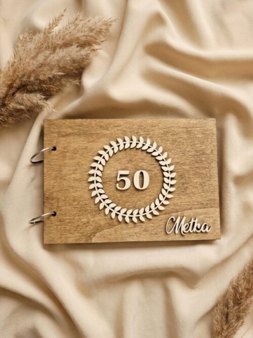 Lesen personaliziran album s krožno gravuro in imenom na ozadju zavese.