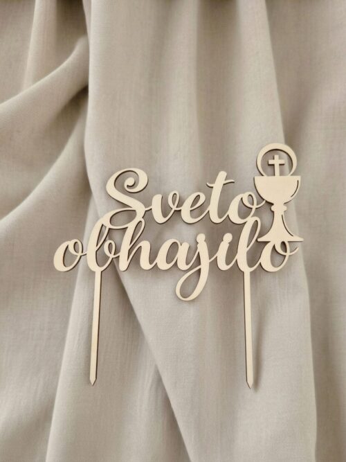 Lesen topper s simbolom keliha za prvo sveto obhajilo na torti pred zaveso